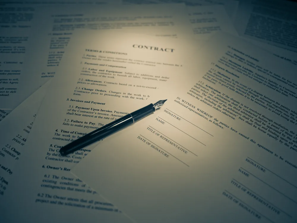 A person signing a legal business formation document with a pen